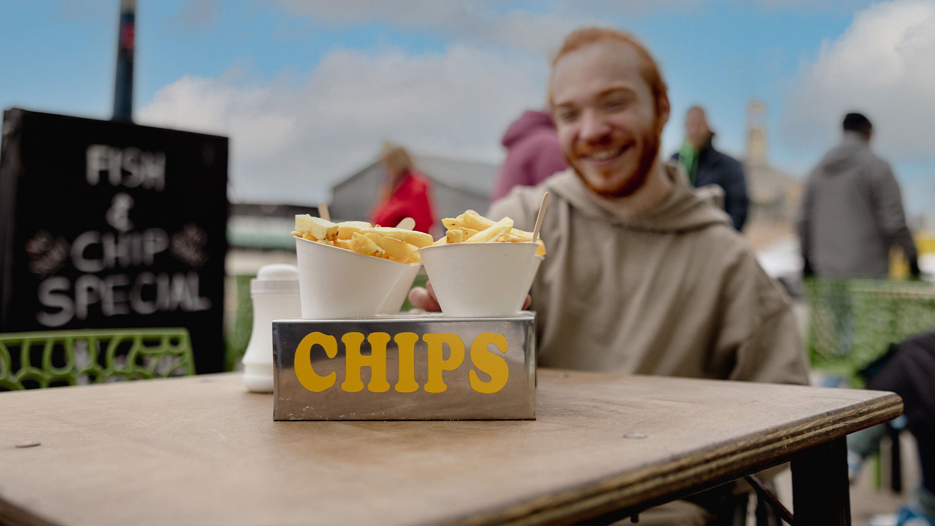Charlie Randall reaches for a chip during an inclusive photo shoot highlighting accessibility.
