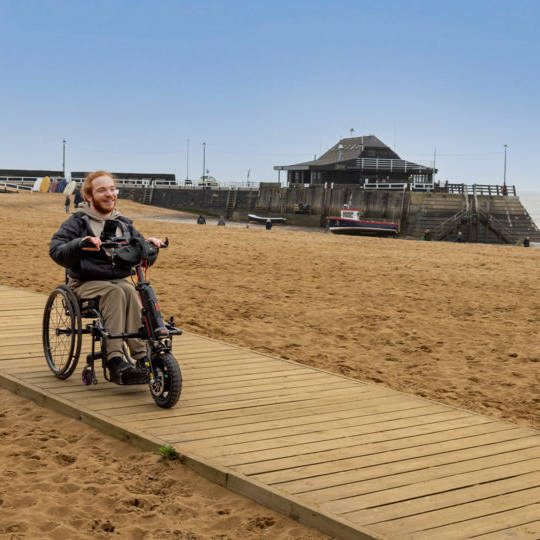 Charlie Randall travels along an accessible walkway on the beach in Margate, Ramsgate and Broadstairs. Photographer is Rachel Airey from Surfr Media.