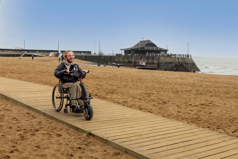 Charlie Randall travels along an accessible walkway on the beach in Margate, Ramsgate and Broadstairs. Photographer is Rachel Airey from Surfr Media.