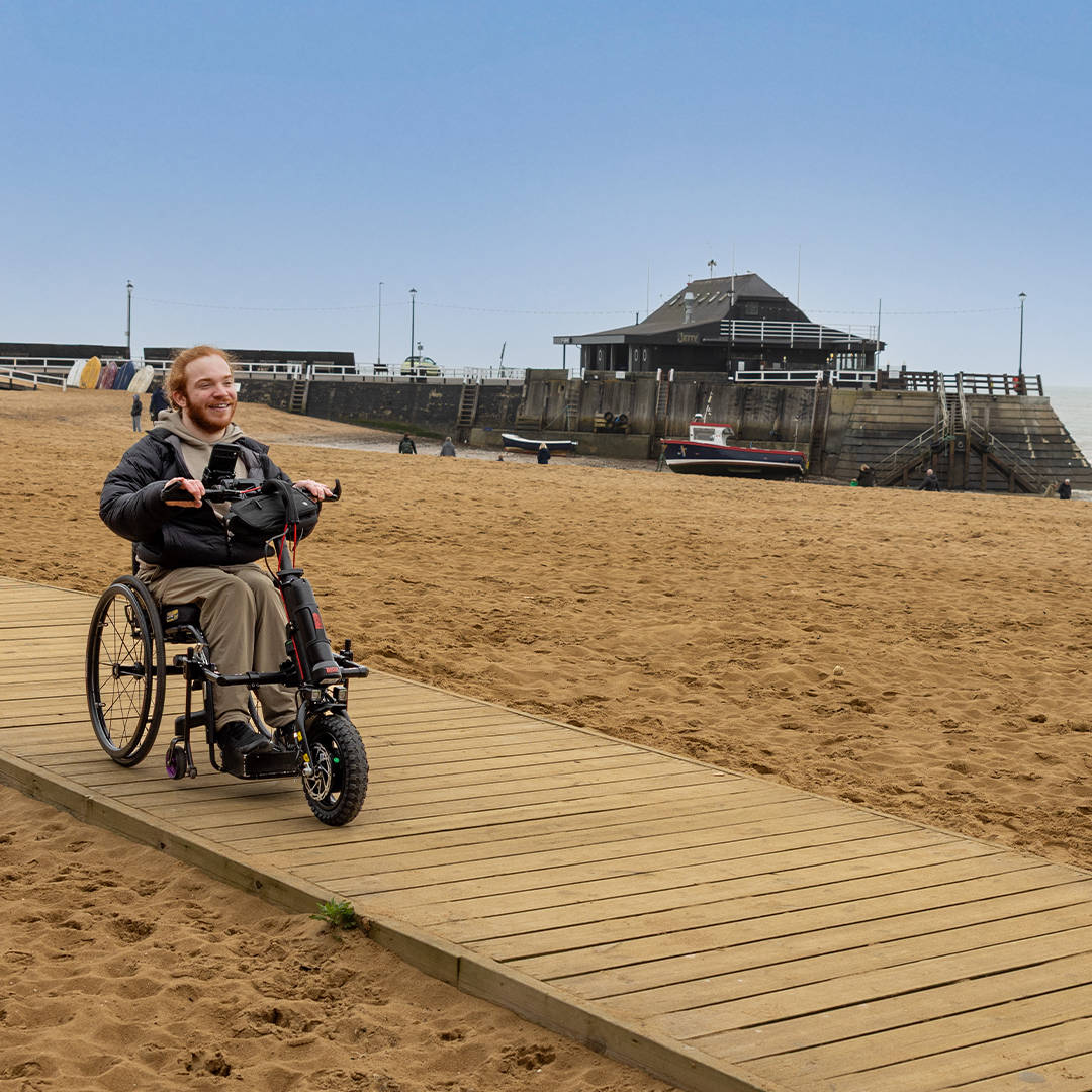 Charlie Randall travels along an accessible walkway on the beach in Margate, Ramsgate and Broadstairs. Photographer is Rachel Airey from Surfr Media.