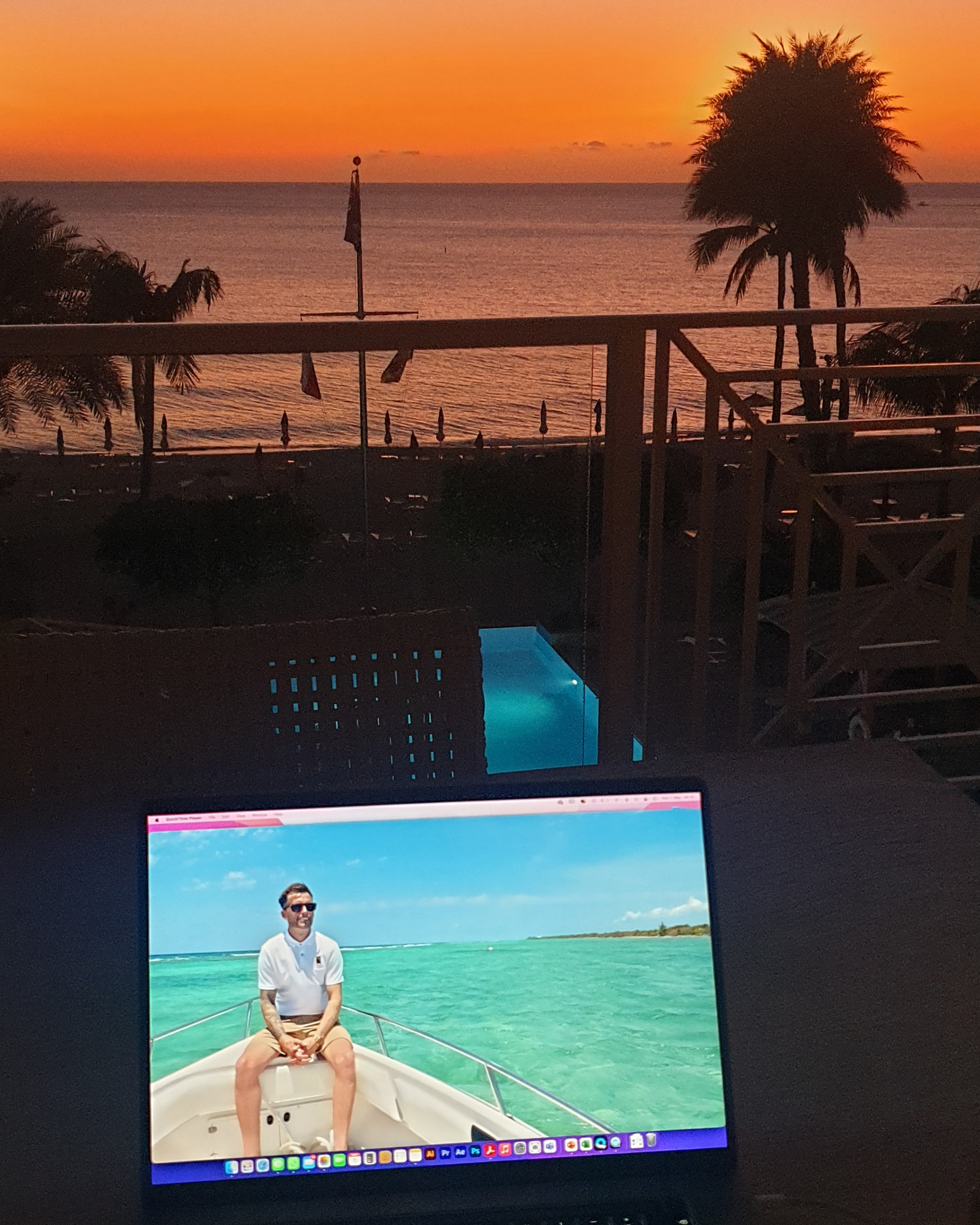 A video edit underway on the balcony of an apartment on Grand Cayman with a sunset in the background.